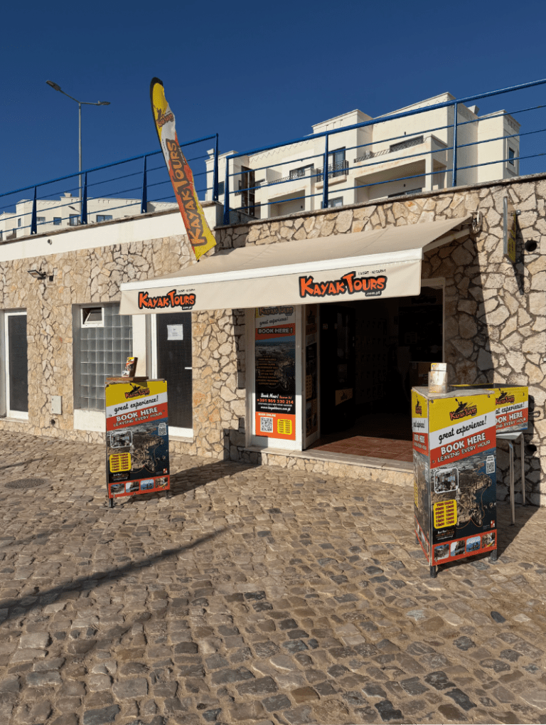 Stone building with 'Kayak Tours' signs and promotional displays outside.