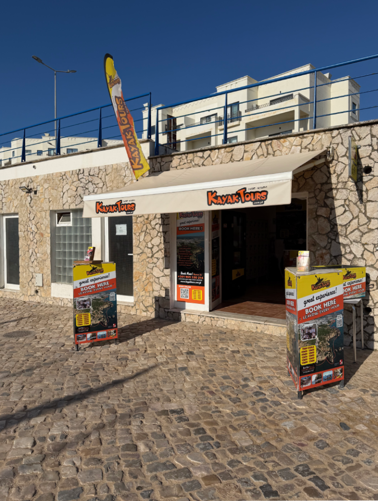 Stone building with 'Kayak Tours' signs and promotional displays outside.